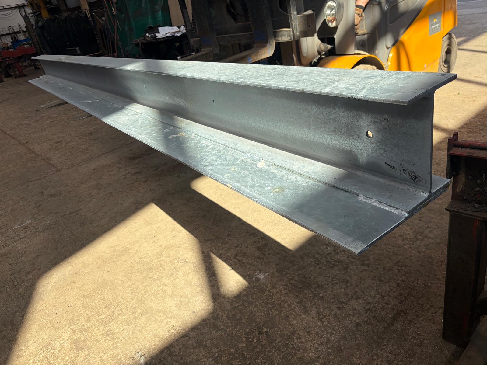 Galvanised steel I-beam loaded on a forklift in the workshop