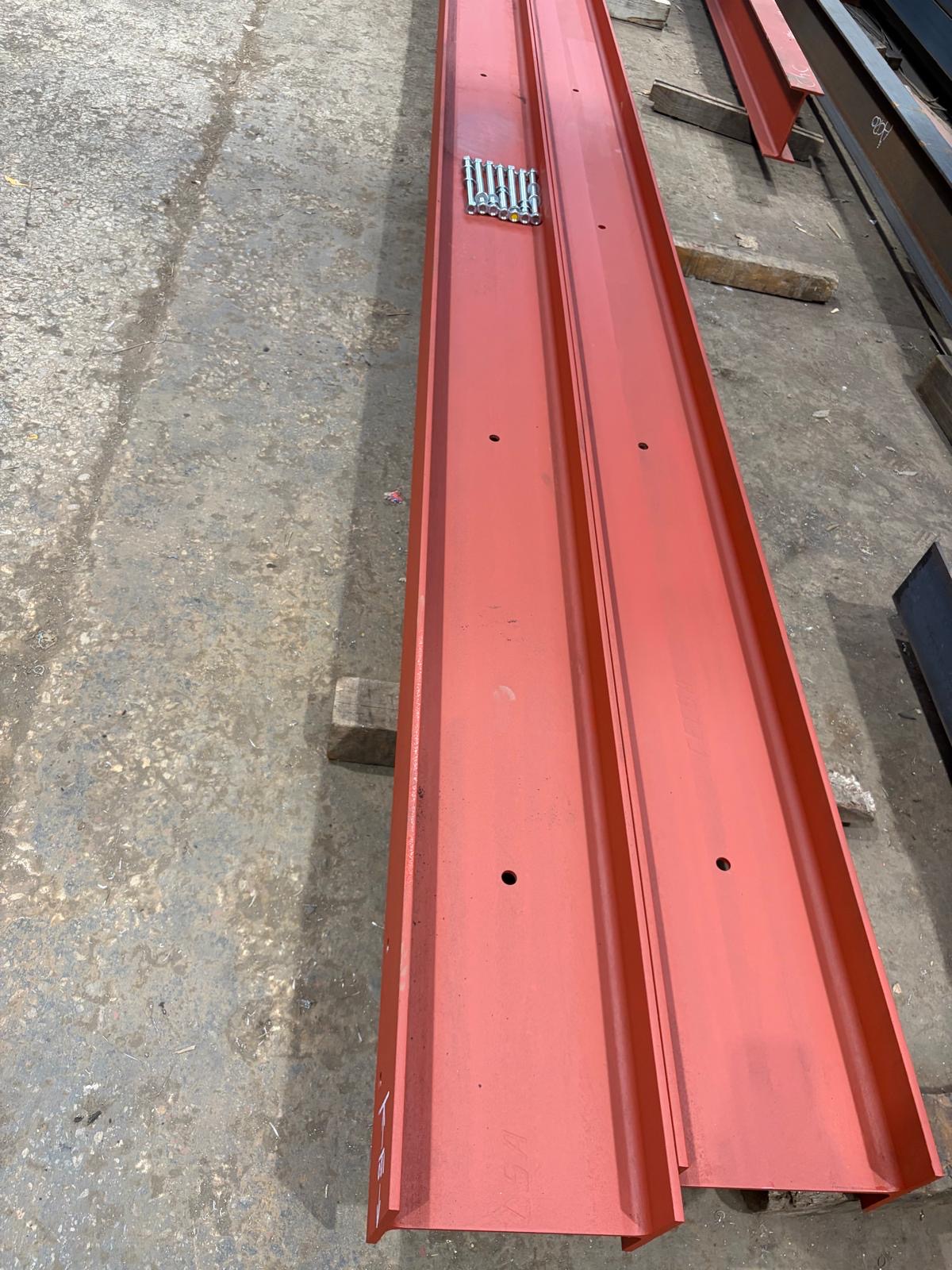 Red painted steel channels with bolt set ready for installation