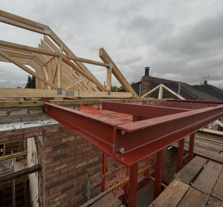 Red structural steel frame supporting a new roof structure